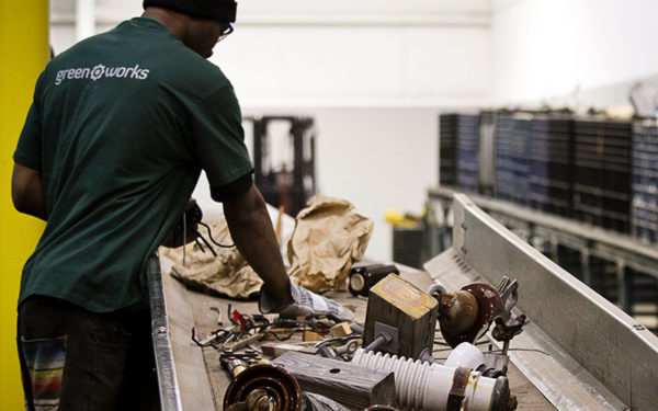 Image of Goodwill greenwork's employee sifting through recycling