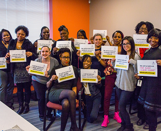 Image of a group of Flip the Script Women holding up #BEBoldForChange signs