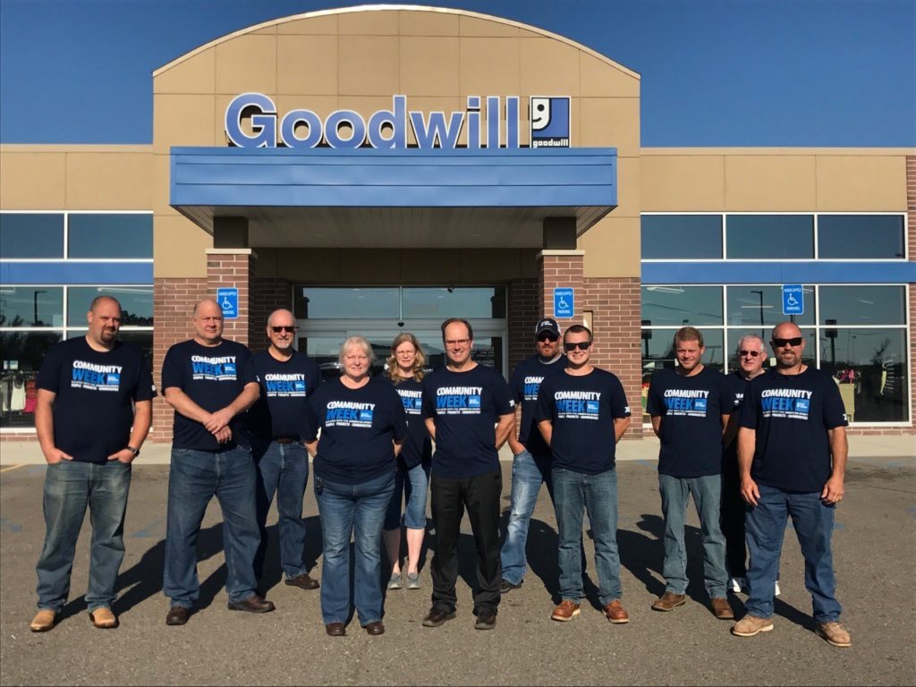 A small group Barton Malow employees pose for a group photo standing in front of the Goodwill Livonia Store.
